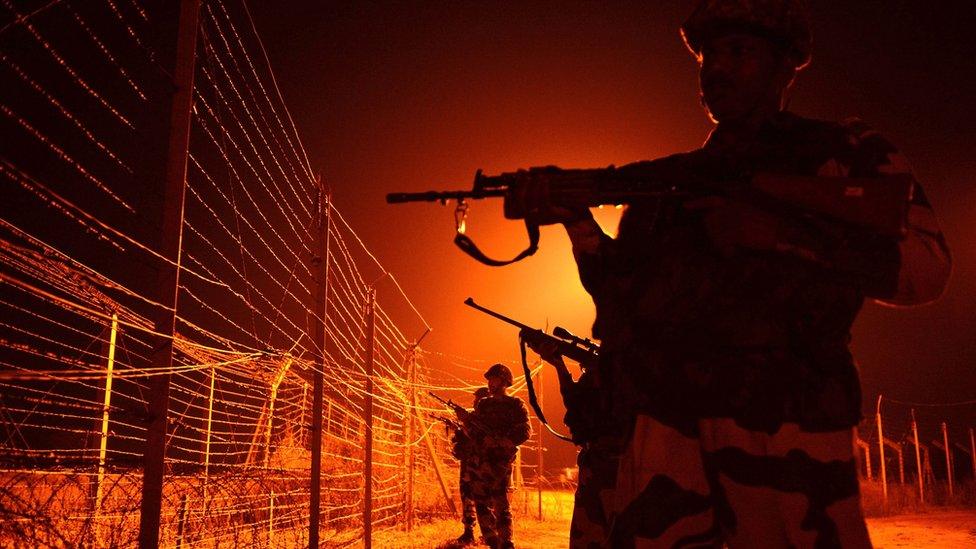 In this file photograph taken on January 17, 2013, Indian Border Security Force (BSF) soldiers patrol along a border fence at an outpost along the Line of Control (LOC) between India-Pakistan at Abdulian, some 38 kms southwest of Jammu