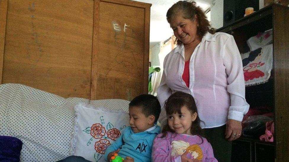 Dona Irlanda Lujano in her house with two of her grandchildren