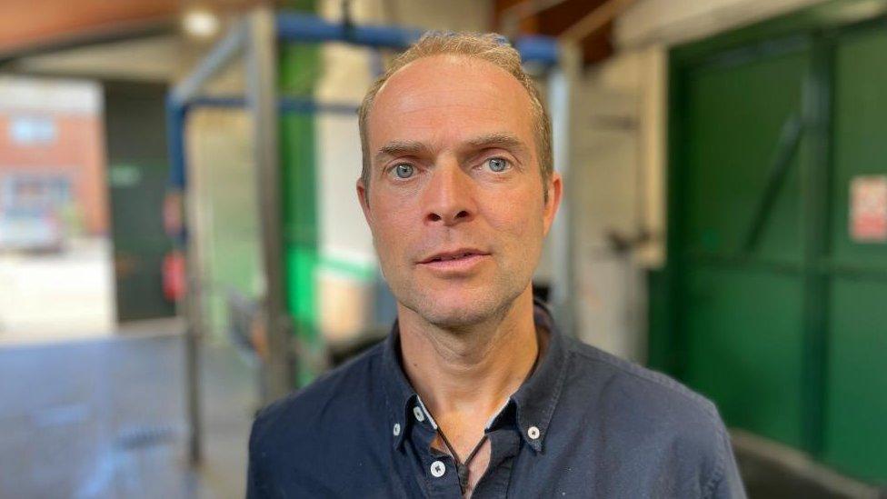 Man with short hair wearing a blue shirt