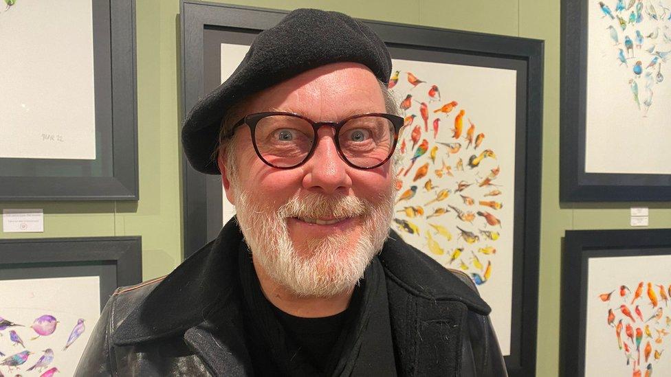 Jim Moir in front of his art works