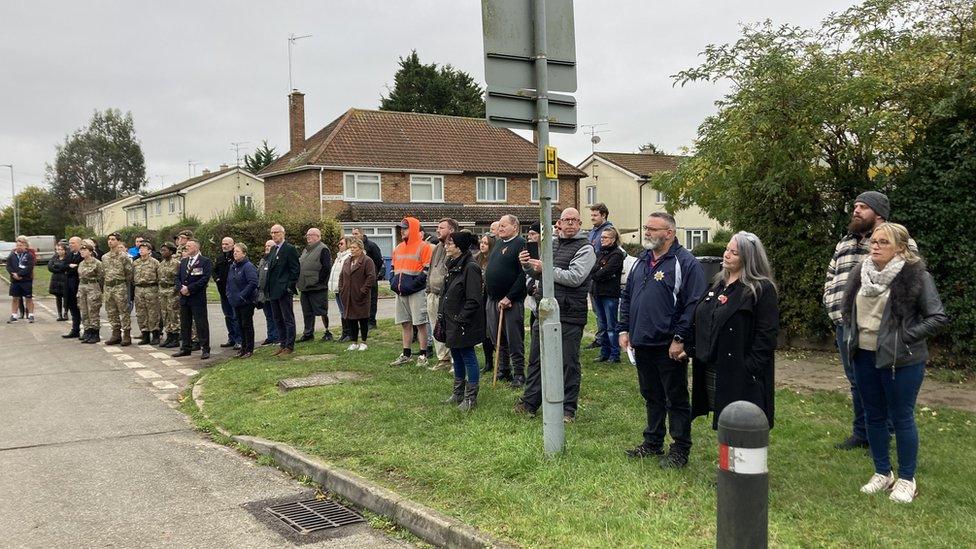 A group of people gathered for the unveiling of the mural