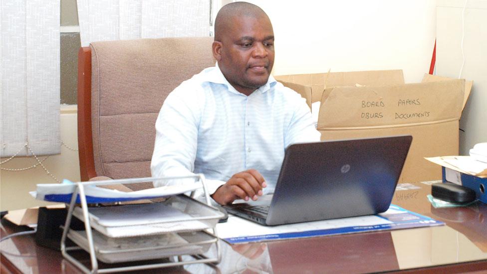 Gospel Mavutula behind his desk in the office.