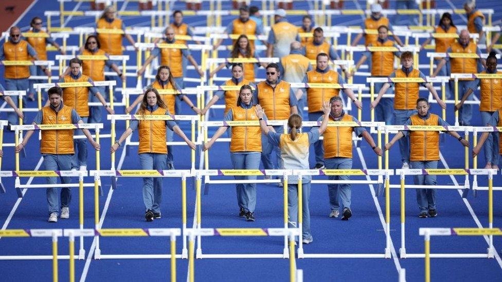 General view of the volunteers moving the hurdles for the men and women's races