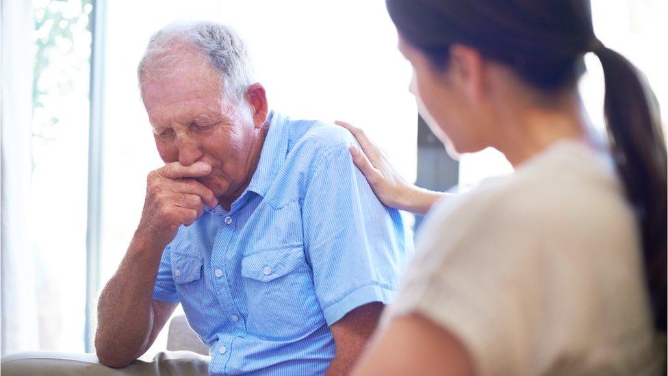 A young doctor talking to an older patient about his terminal illness