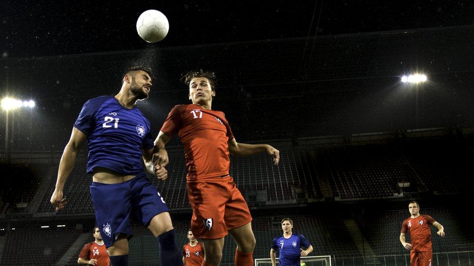 Footballers going up to head a ball