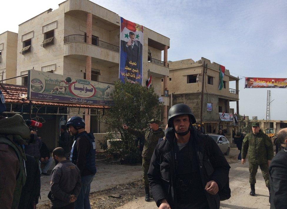 Journalists walk around Salma, Syria