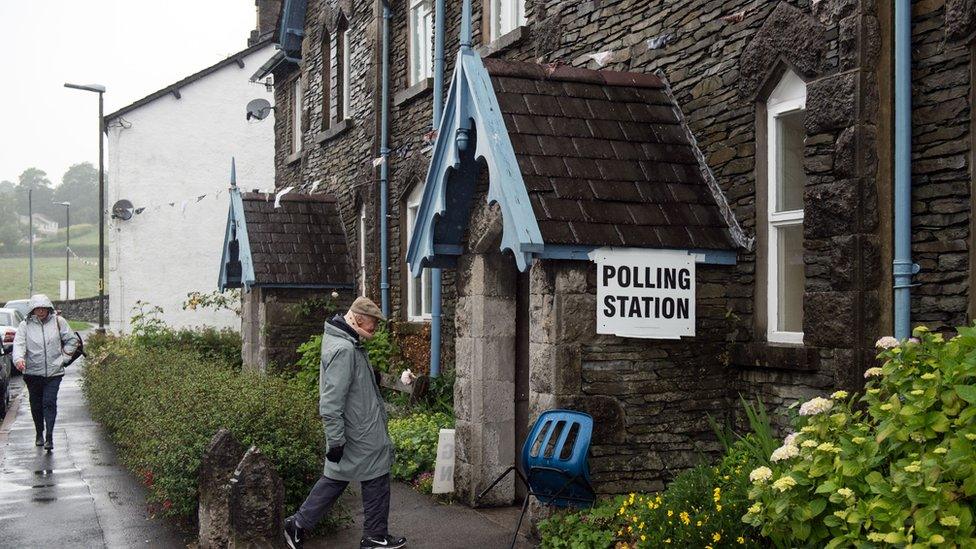 Voters arrive at a polling station to cast their vote in Staveley, northwest England