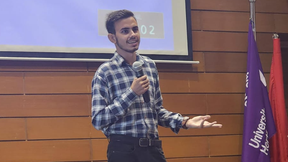 Pakistani university student Murtaza Habib holds a microphone while speaking at a conference