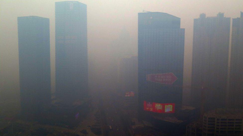 This picture taken on 8 November 2015 shows a residential block covered in smog in Shenyang, China's Liaoning province