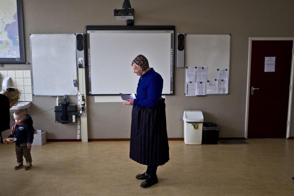 An elderly woman waits her turn to receive her ballot prior to casting her vote for Dutch general elections at a polling station set up in a school in Staphorst, Netherlands, 15 March