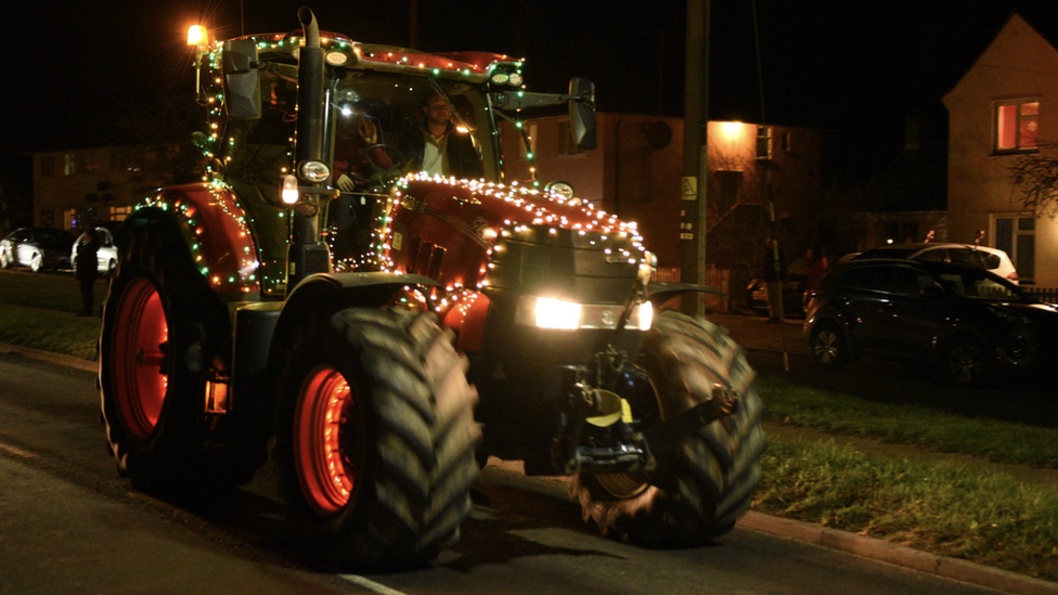 A tractor decorated with Christmas lights