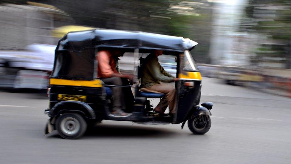 Auto-rickshaw speeding down street