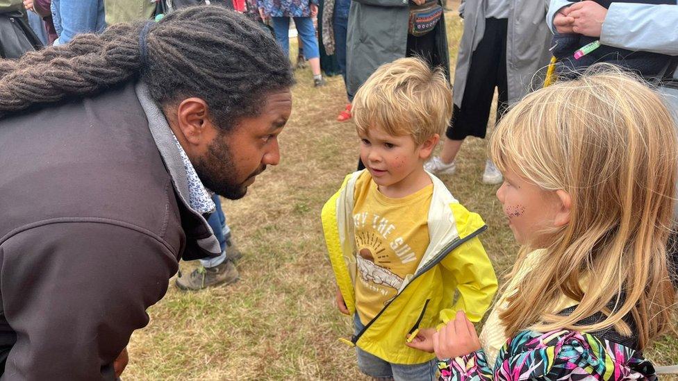 Yassin talking to young children