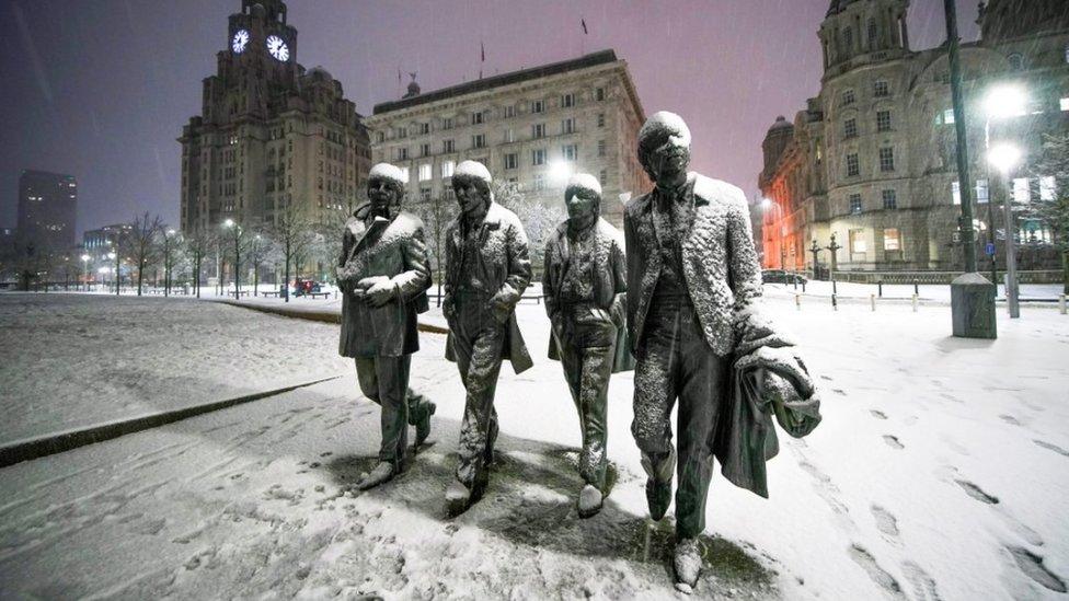 Snow falls on the Beatles Statue at Pier Head, Liverpool