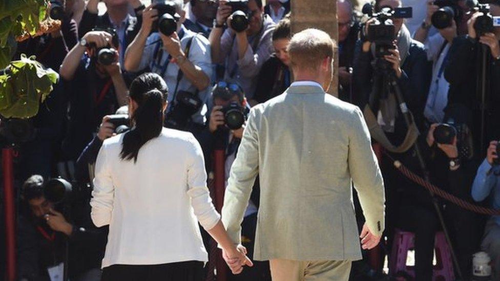 Harry and Meghan being met by the press