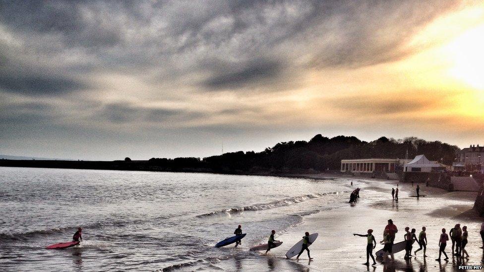 Young lifeguards carry out sea training exercises as the sun goes down over Barry Island