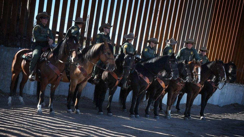 Border Patrol officers at the US border wall