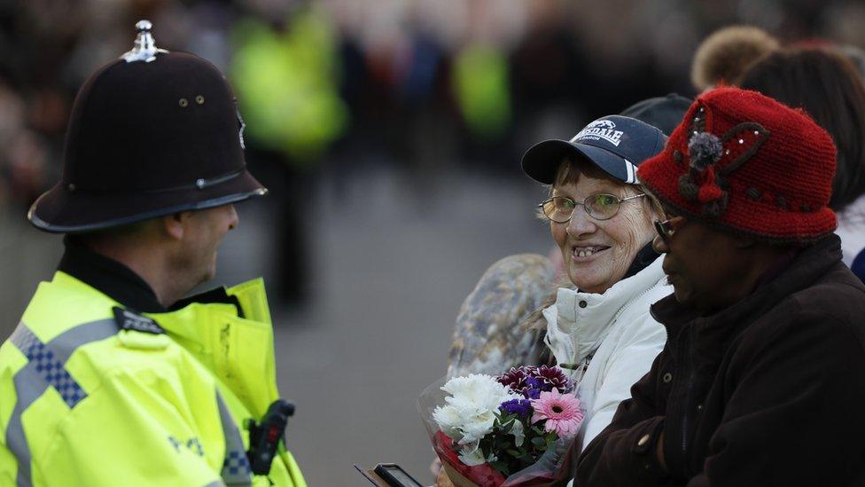 Police officer wearing helmet speaking to public