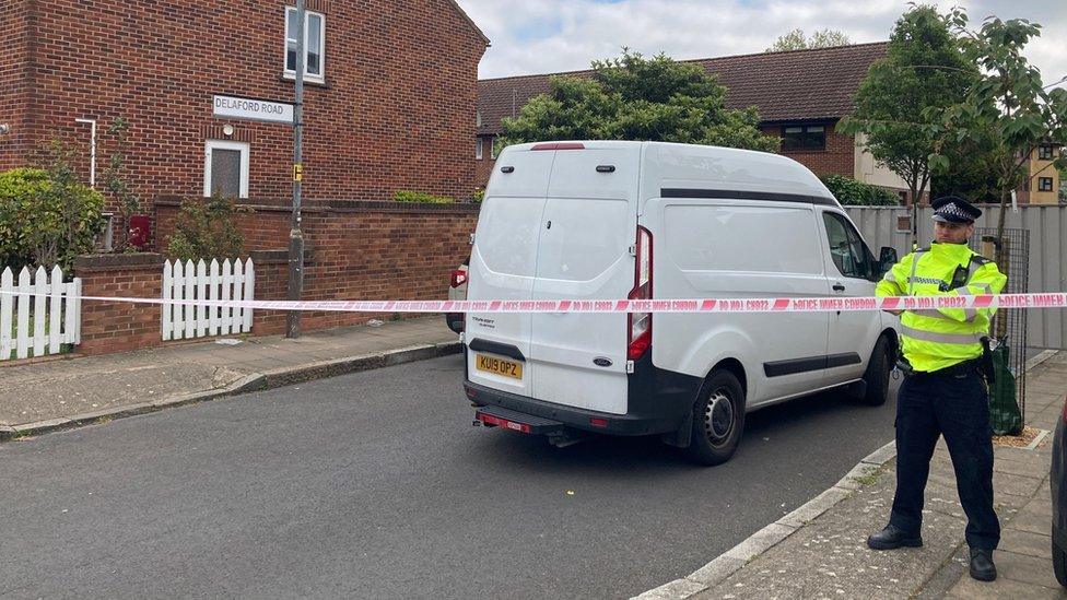 Police officer stands outside a police cordon in Delaford Road