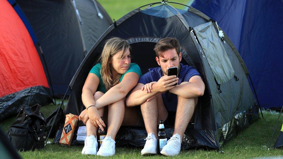 People in a tent in the queue