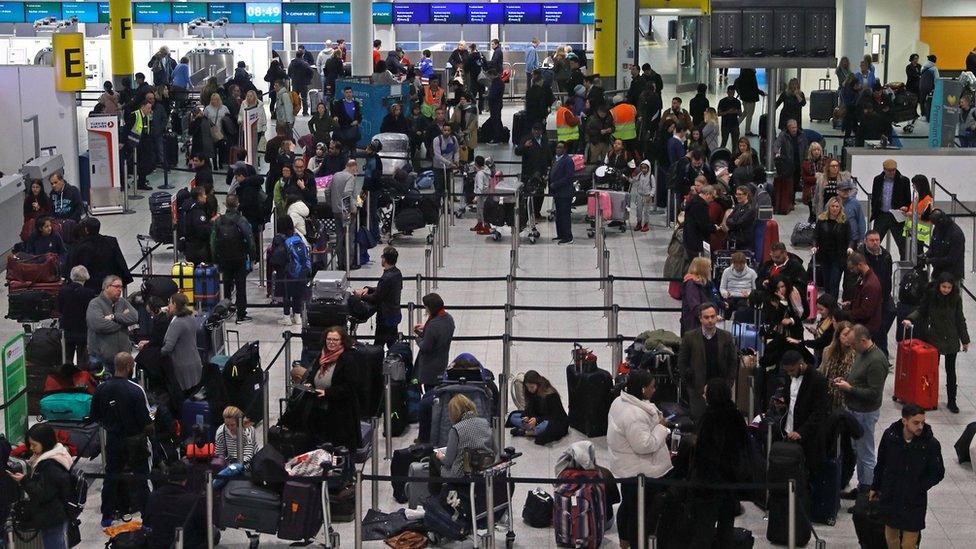 Passengers wait around in the South Terminal building at Gatwick Airport after drones flying illegally over the airfield forced the closure of the airport in Gatwick