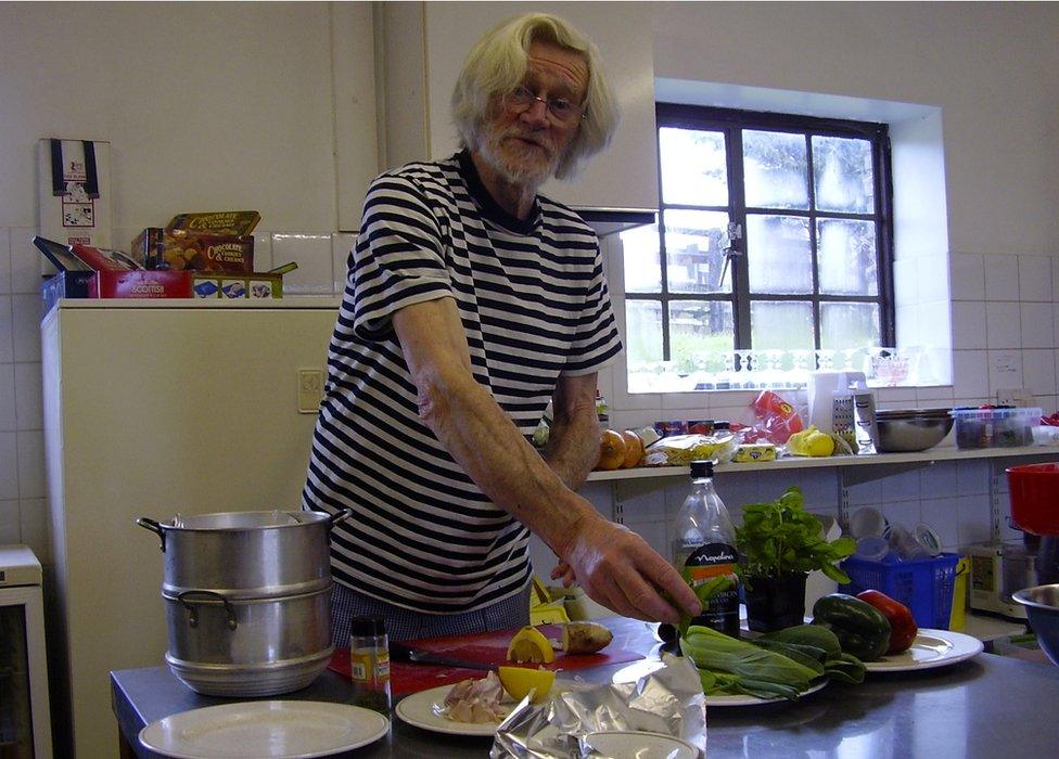 Tony Gibbons from the Friendly Food Club in a kitchen with fruit and vegetables