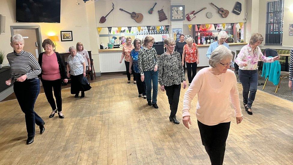 women line dancing in a hall