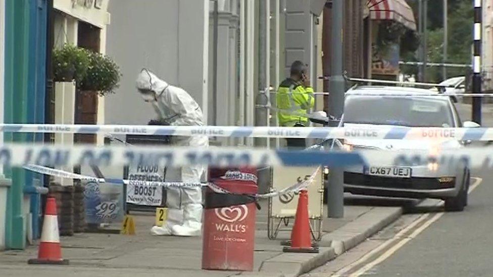 Police and forensics officers examine the scene