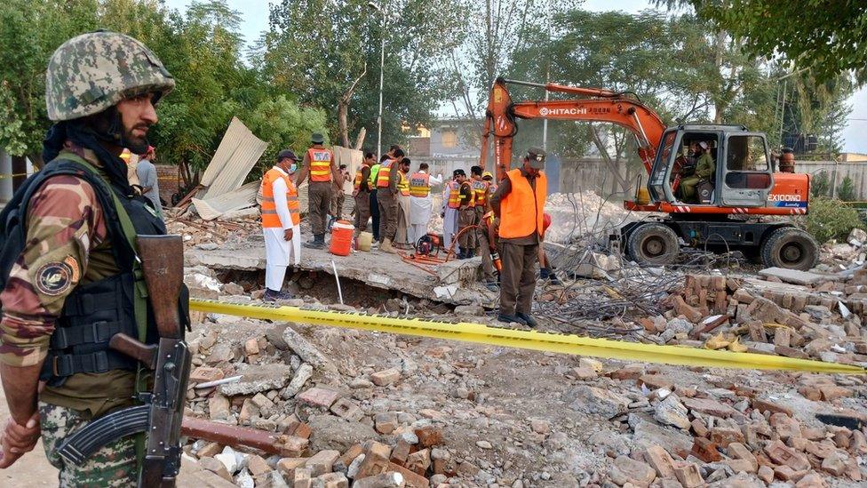 A Pakistani soldier stands guard as rescuers search through the debris at the blast site in Hangu. Photo: 29 September 2023