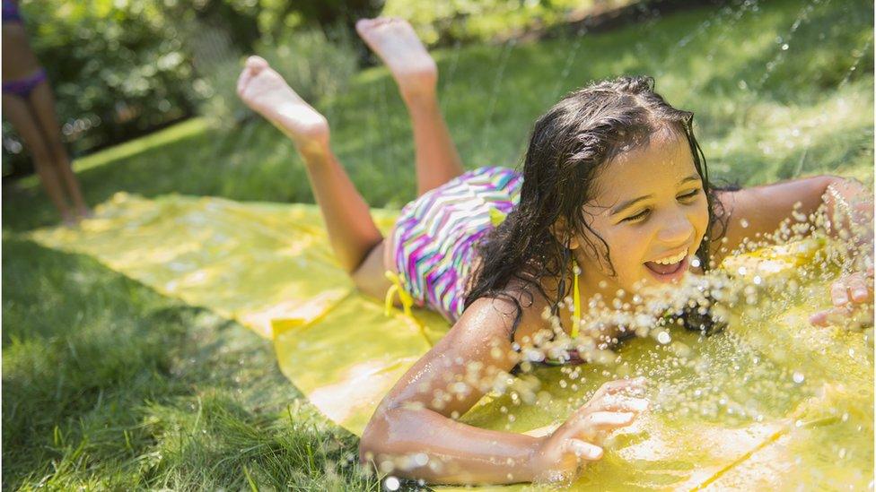 a-girl-slides-on-her-stomach-on-a-water-slide