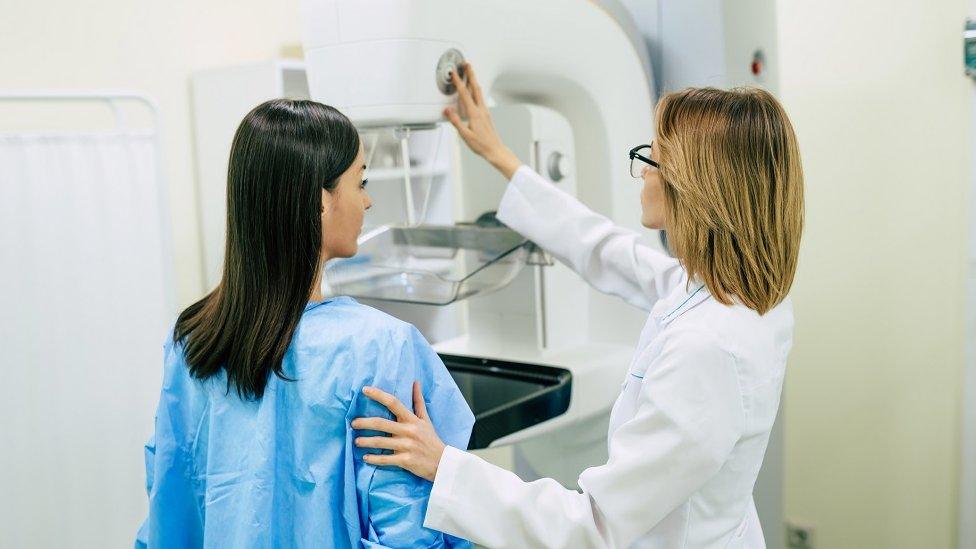 A doctor speaks to a woman during a screening for breast cancer