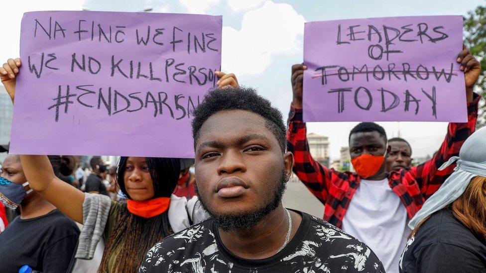 Demonstrators hold banners during a protest against alleged police brutality, in Lagos, Nigeria