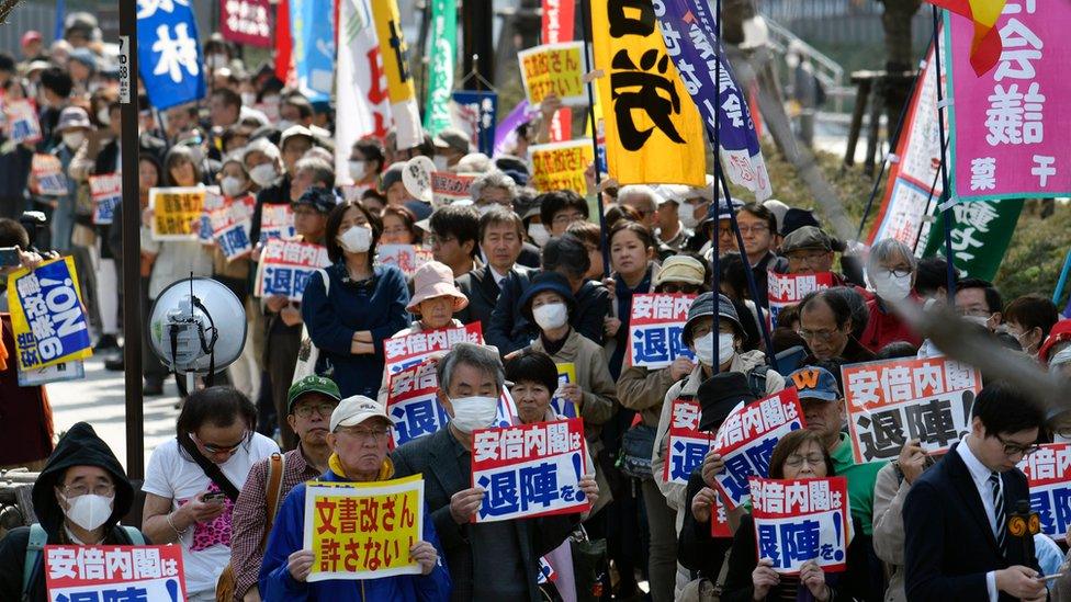 Protesters hold placards outside the National Diet Building during a protest against Japanese Prime Minister Shinzo Abe's cabinet in Tokyo, Japan, 13 March 2018