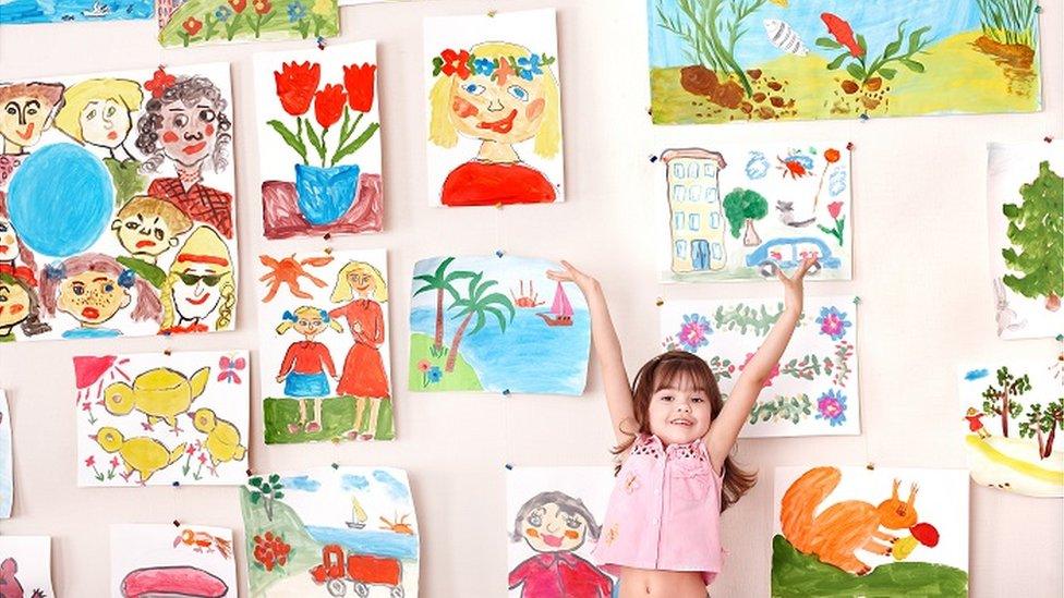 Child showing off artworks