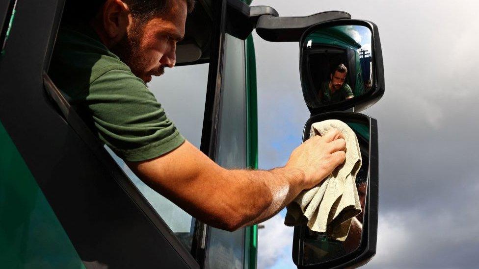 British driver Steven Abbott, 35, sits in his cab while taking a break from driving at Ashford International truck stop.