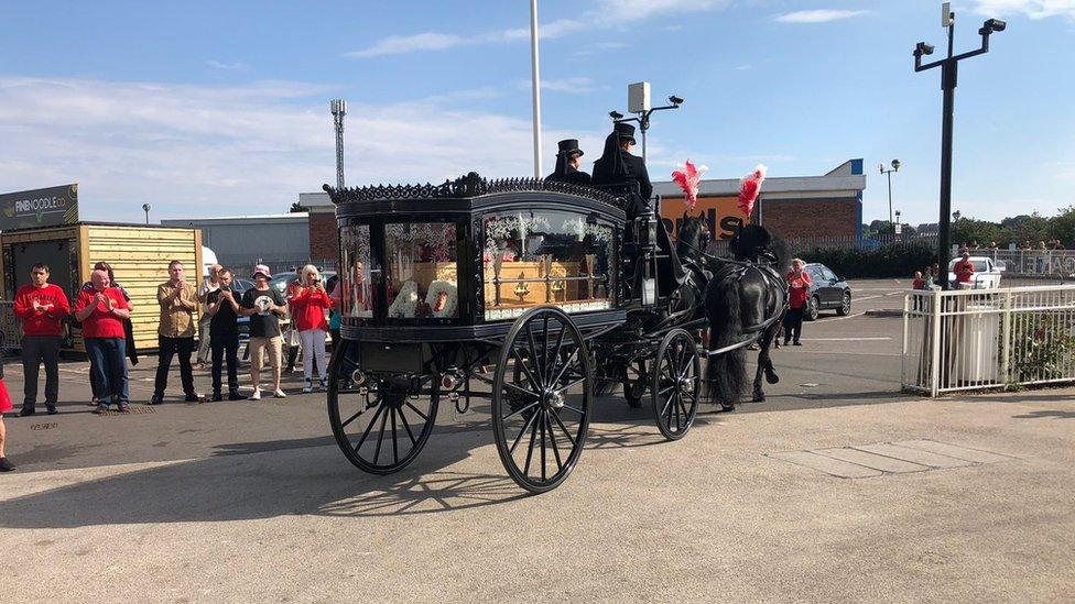 Horse-drawn carriage leaving stadium