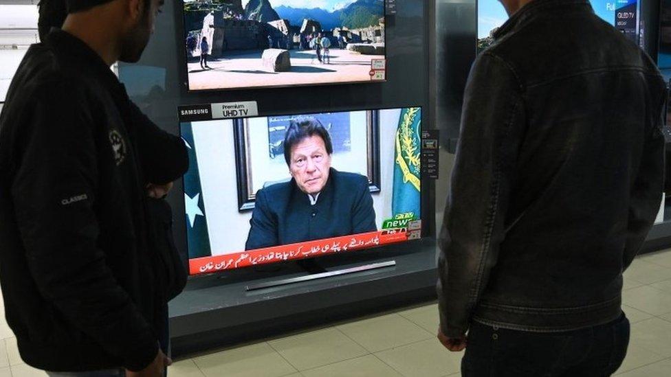 Pakistani people watch the television as Prime Minister Imran Khan speaks to the population about the suicide bombing in Indian-administered Kashmir that happened on February 14, in Islamabad on February 19, 2019