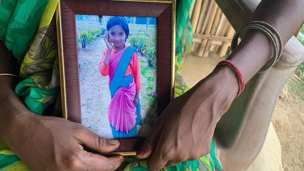 Anjali Kharia holds a photo of her daughter