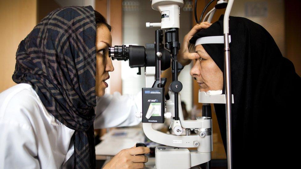 A doctor examines a patient's eyes