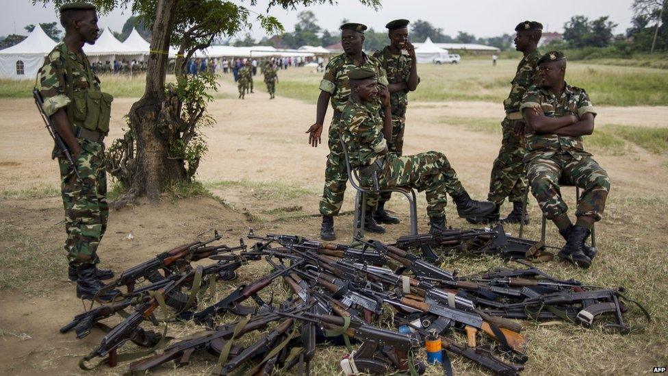 Military stand next to a pile of weapons, left whilst soldiers go to vote at a polling station in the neighbourhood of Musaga in Bujumbura on June 29, 2015.