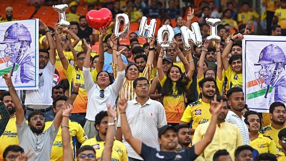 Fans of Chennai Super Kings' captain Mahendra Singh Dhoni, cheer before the start IPL final cricket match