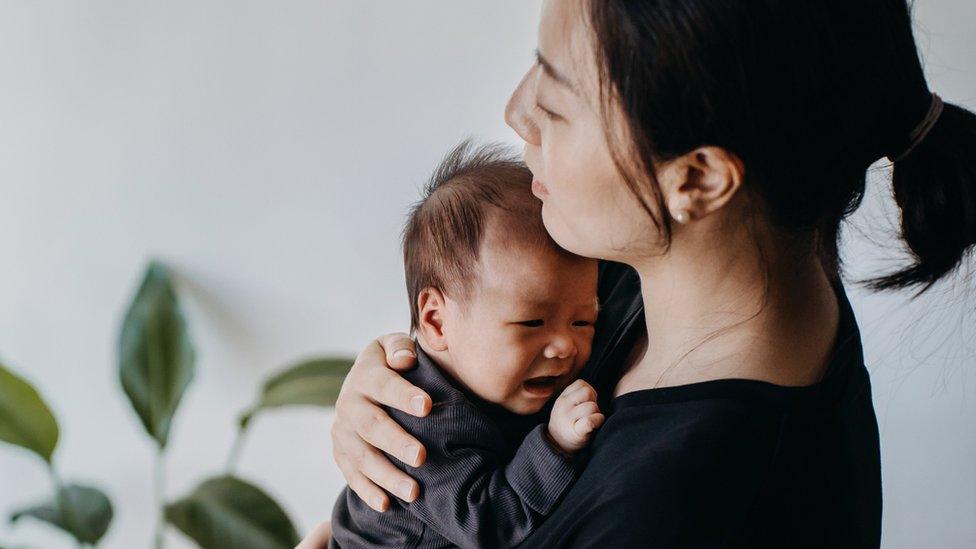 Woman holds crying baby