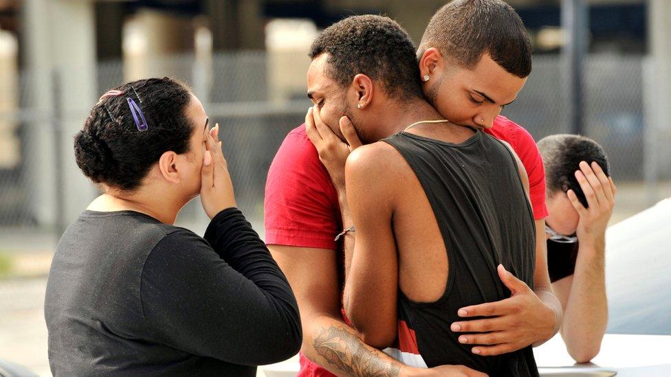 Friends and family members embrace outside the Orlando Police Headquarters during the investigation of a shooting at the Pulse night club, where as many as 20 people have been injured after a gunman opened fire, in Orlando, Florida, U.S June 12, 2016.