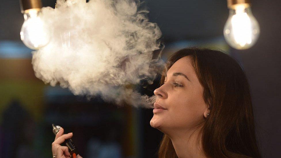 Woman vaping in outdoor setting