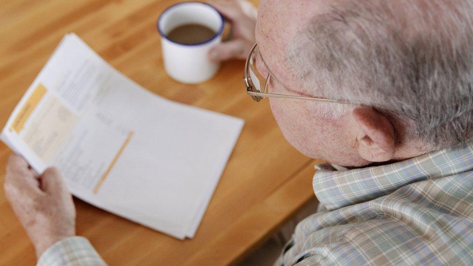 Elderly man looking at bills