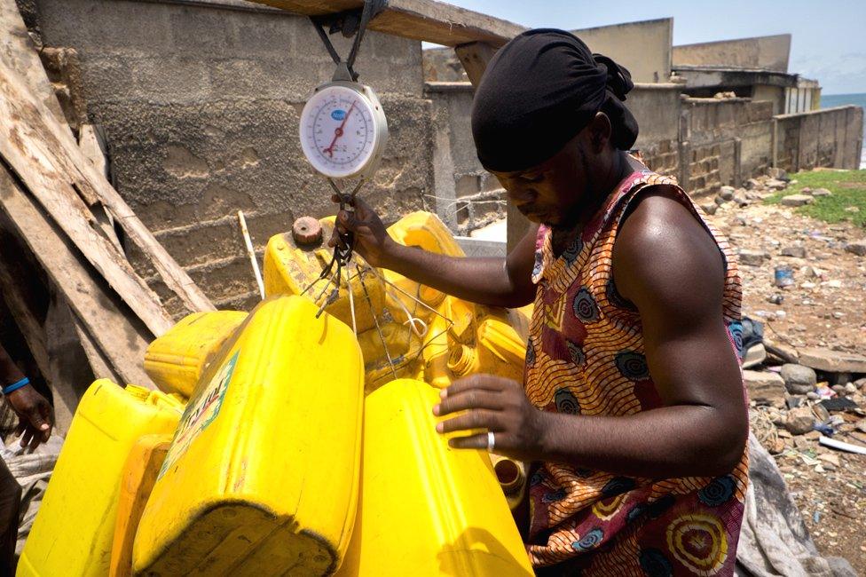 A an weighing jerrycans in La - Accra, Ghana