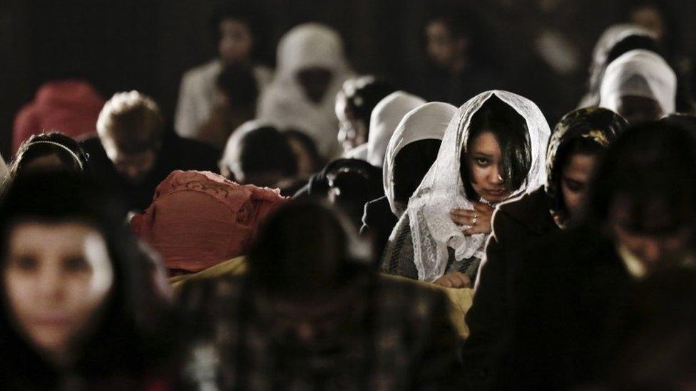 Women pray during Christmas Eve Mass at St. Mark"s Cathedral, in Cairo, Egypt, Wednesday, Jan. 6, 2016
