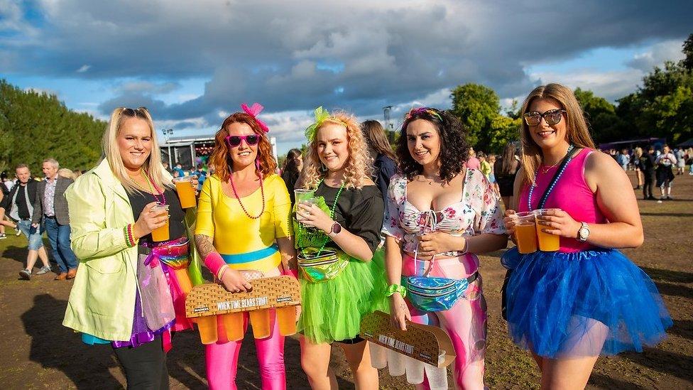 Women dressed in 80s-style colourful outfits at a concert in Falls Park on Saturday night