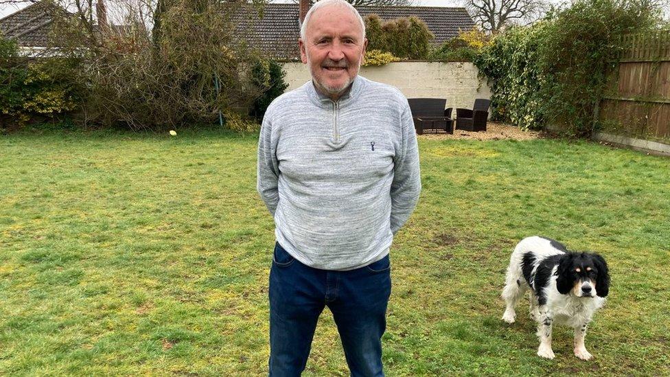 Former England football player Barry bridges in the garden of his home in Norfolk with his dog, Roger