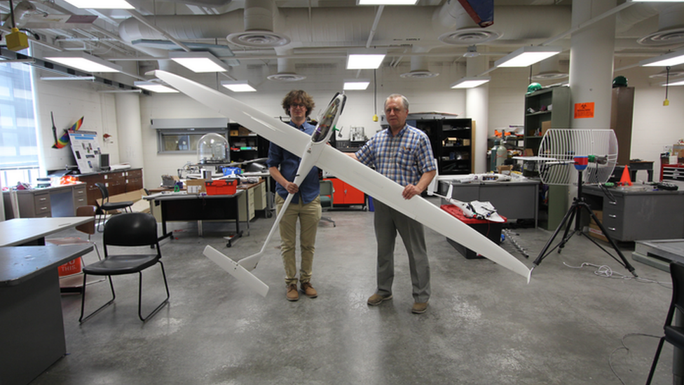 Researchers hold an experimental sailplane.